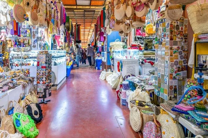 An aisle of the souk lined with stalls of woven baskets, bags, textiles and slippers