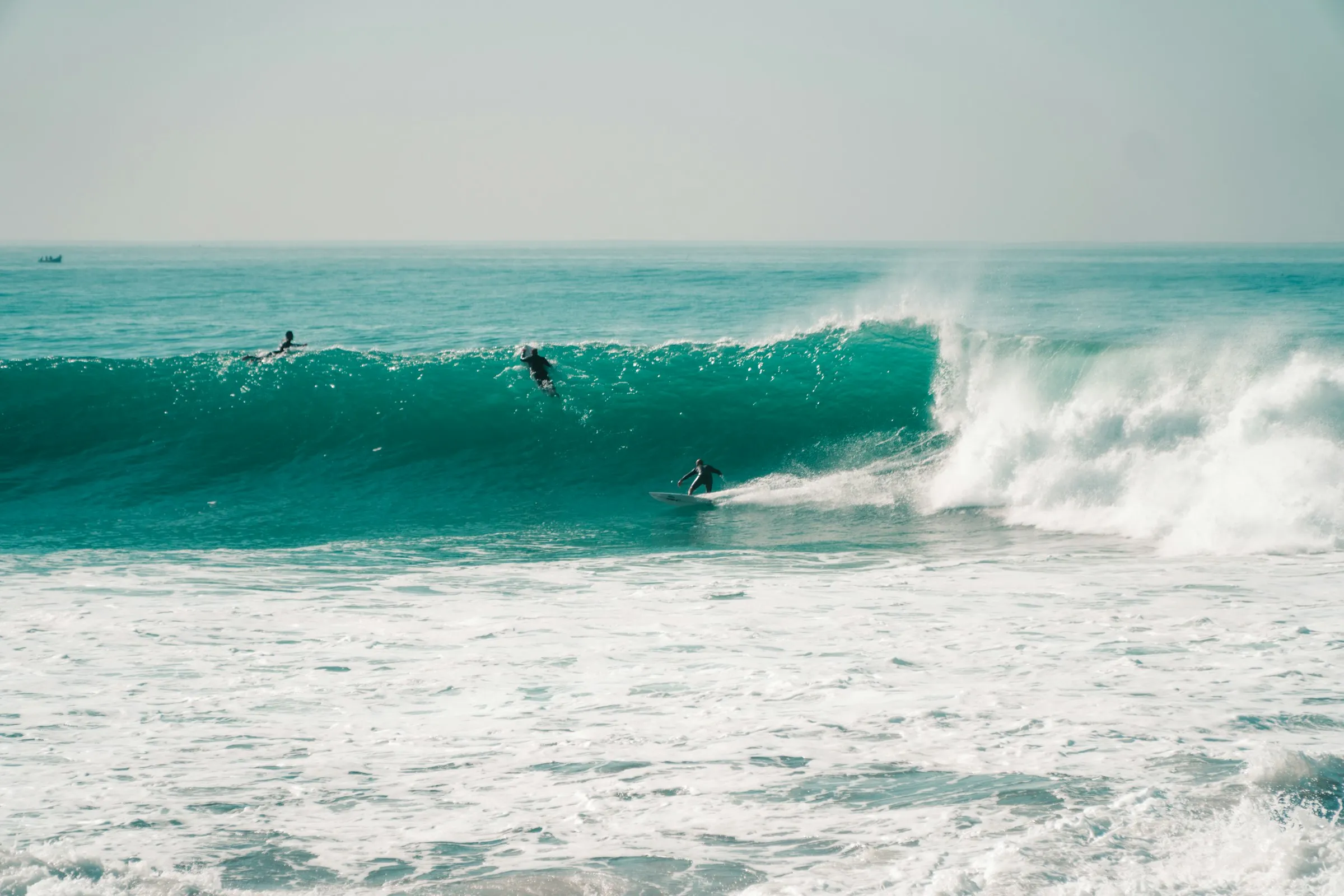 Surfers riding a peeling right-hander at Anchor Point, Taghazout