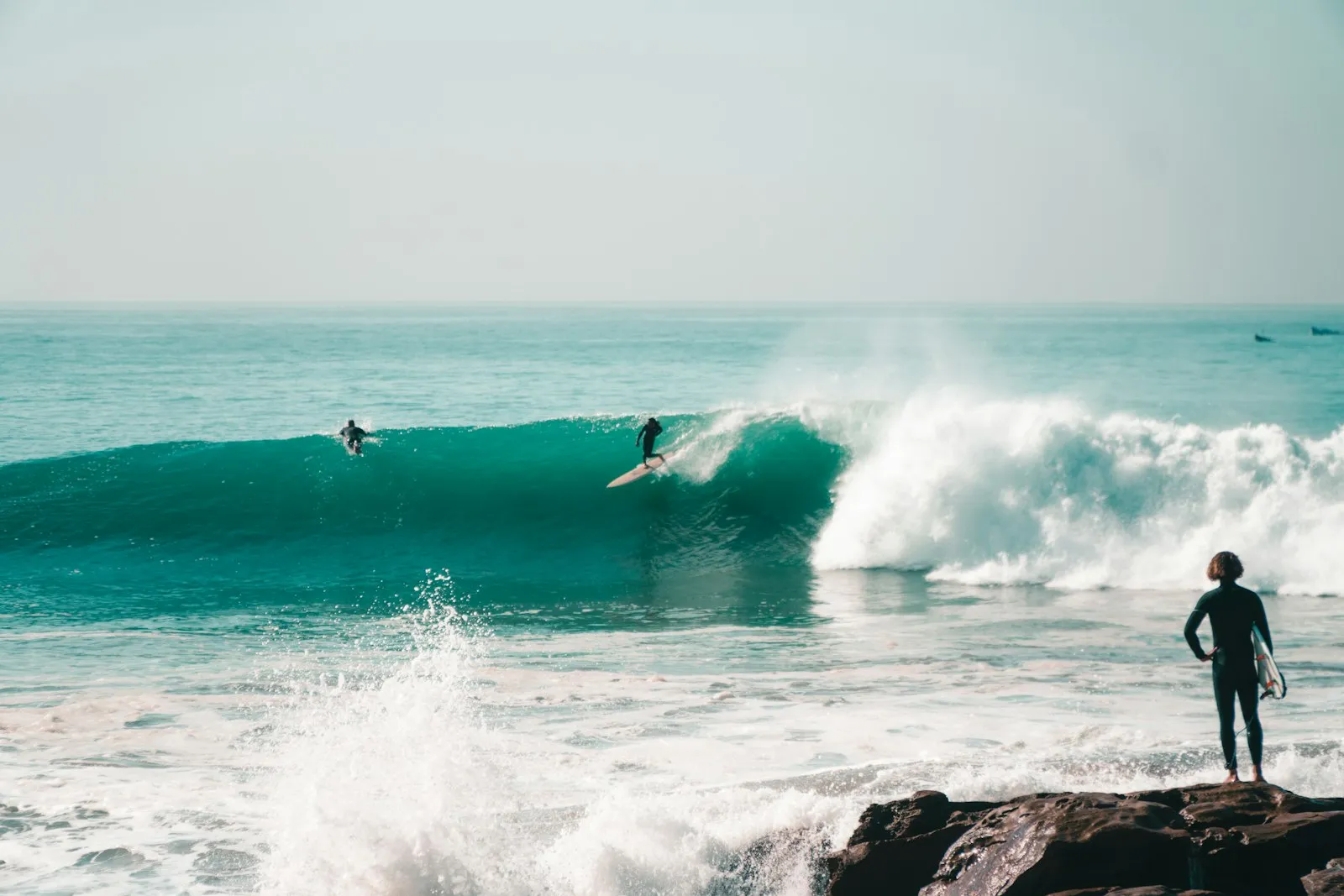 A surfer on the rocks watching the swell roll into Taghazout
