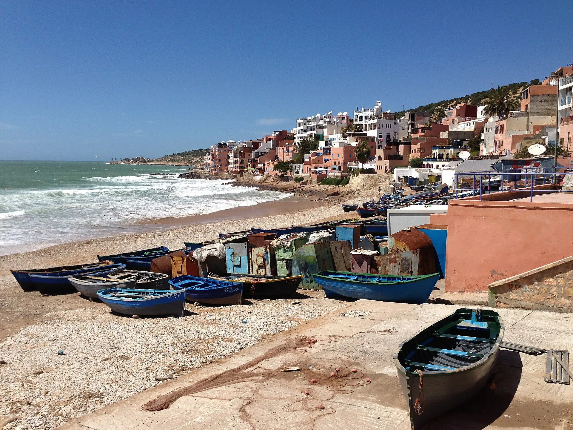 Painted houses and blue fishing boats on the beach at Taghazout